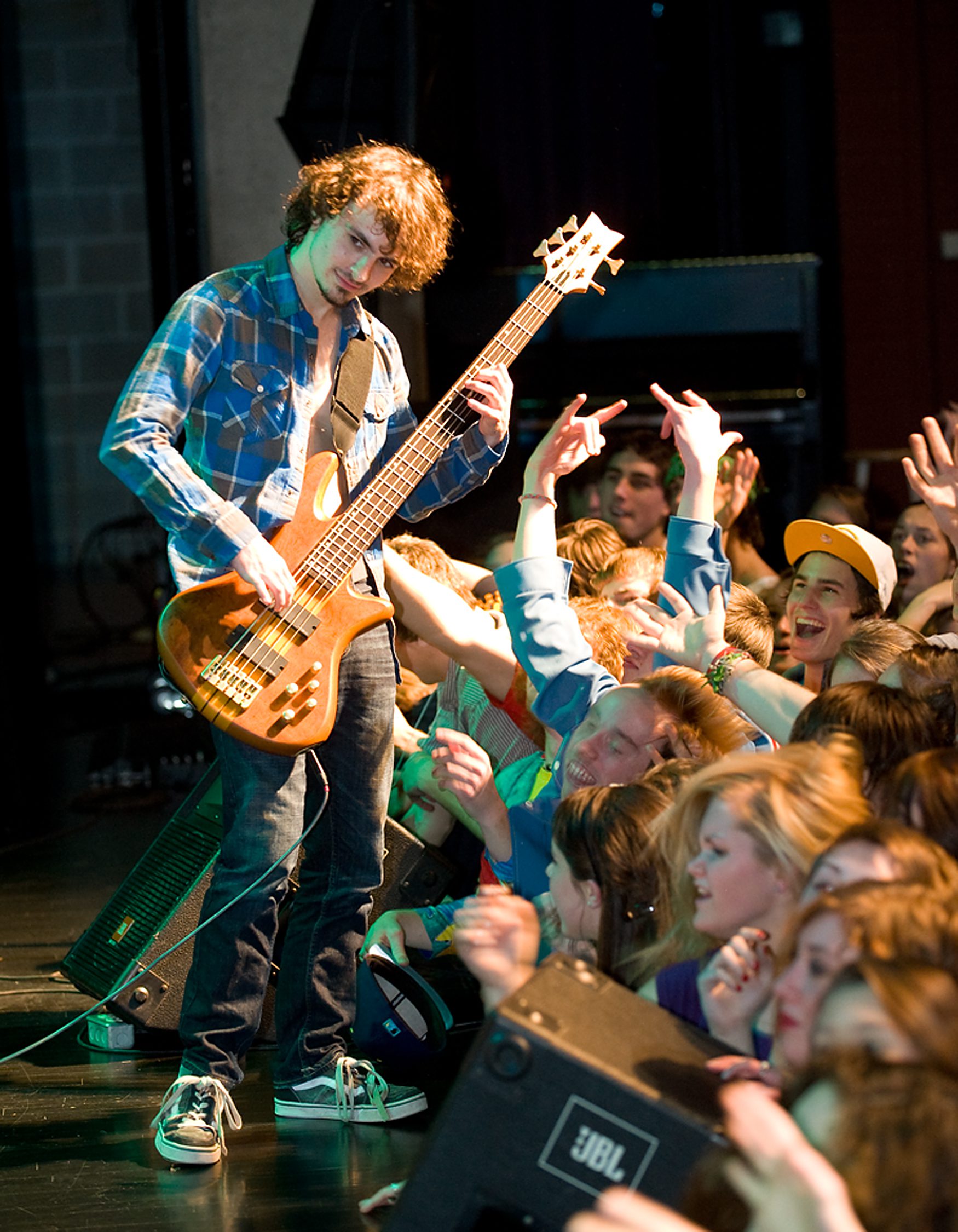 family and children portrait photographer. boy playing bass guitar on stage with fans cheering Youth Photography
